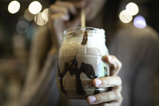 Chocolatey drink with syrup drizzled down the inside of the glass